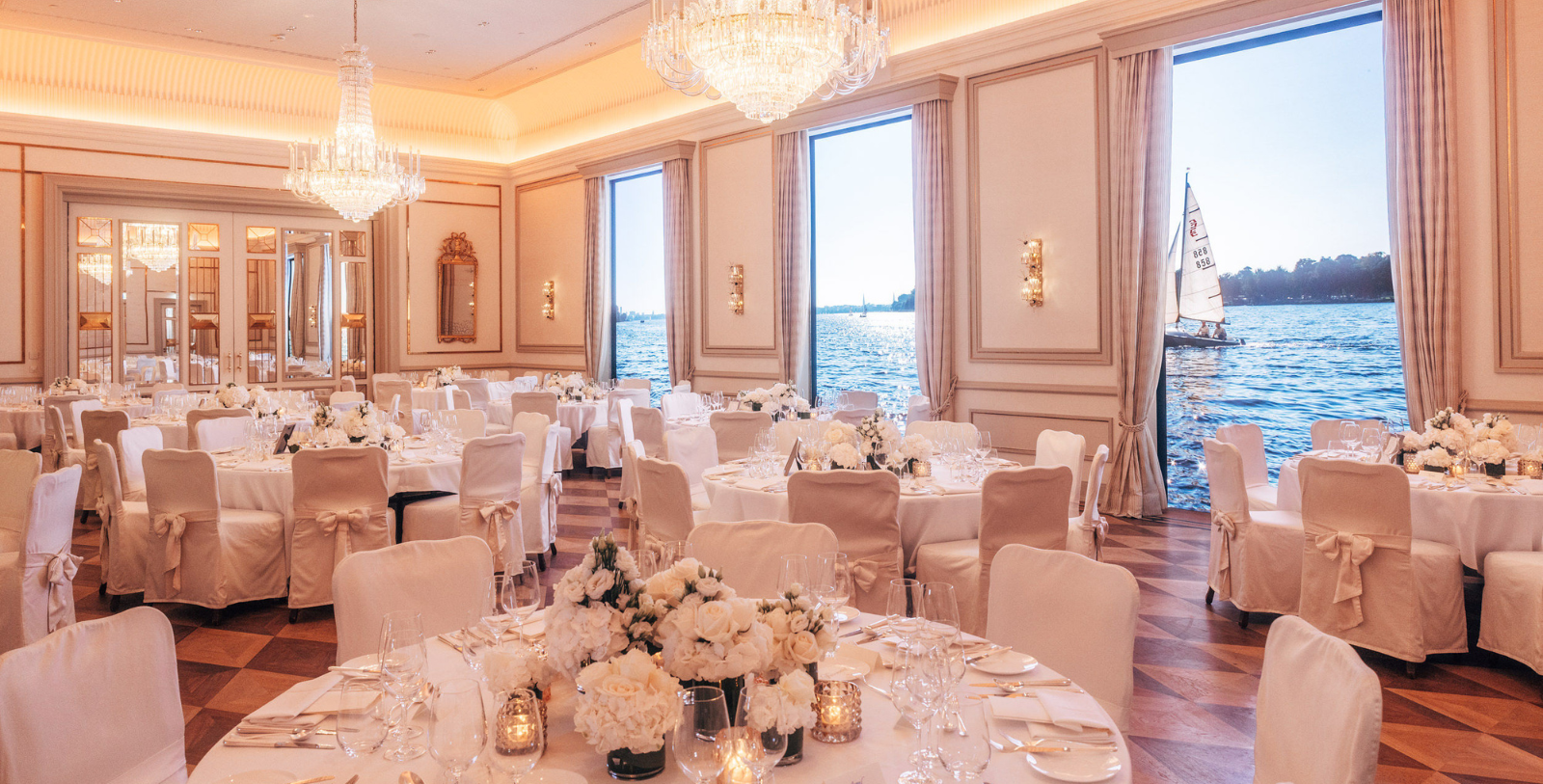 a room with tables and chairs and chandeliers