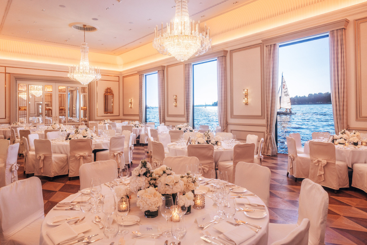 a room with tables and chairs and chandeliers