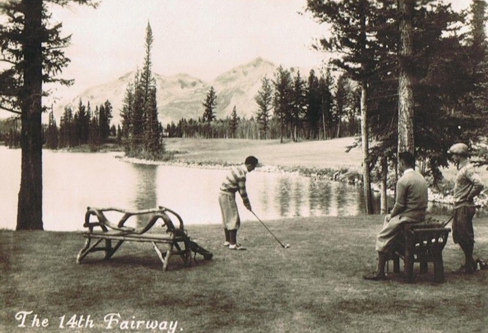 a man playing golf near a lake