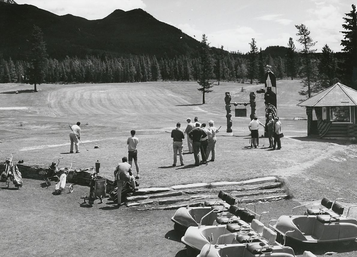 a group of people standing around a totem pole