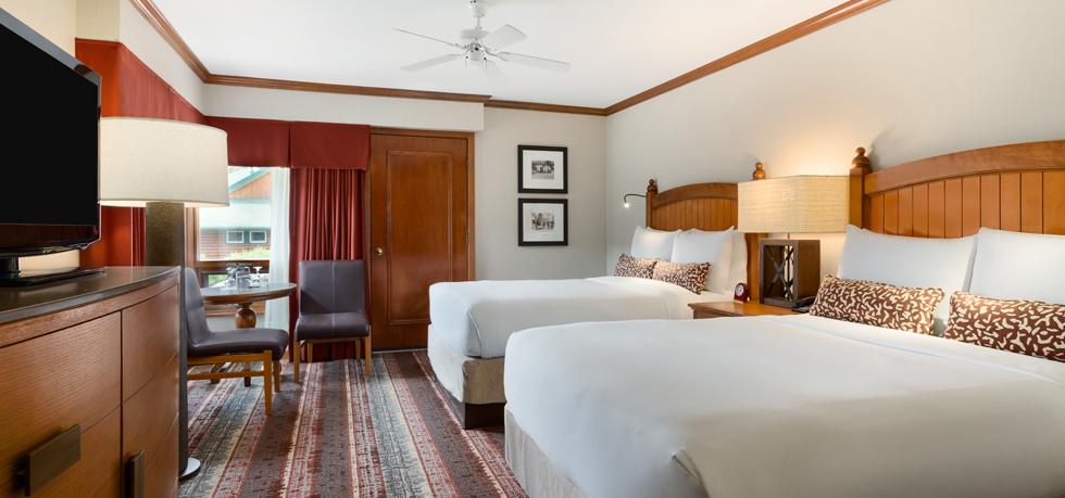 a room with two beds and a fan
