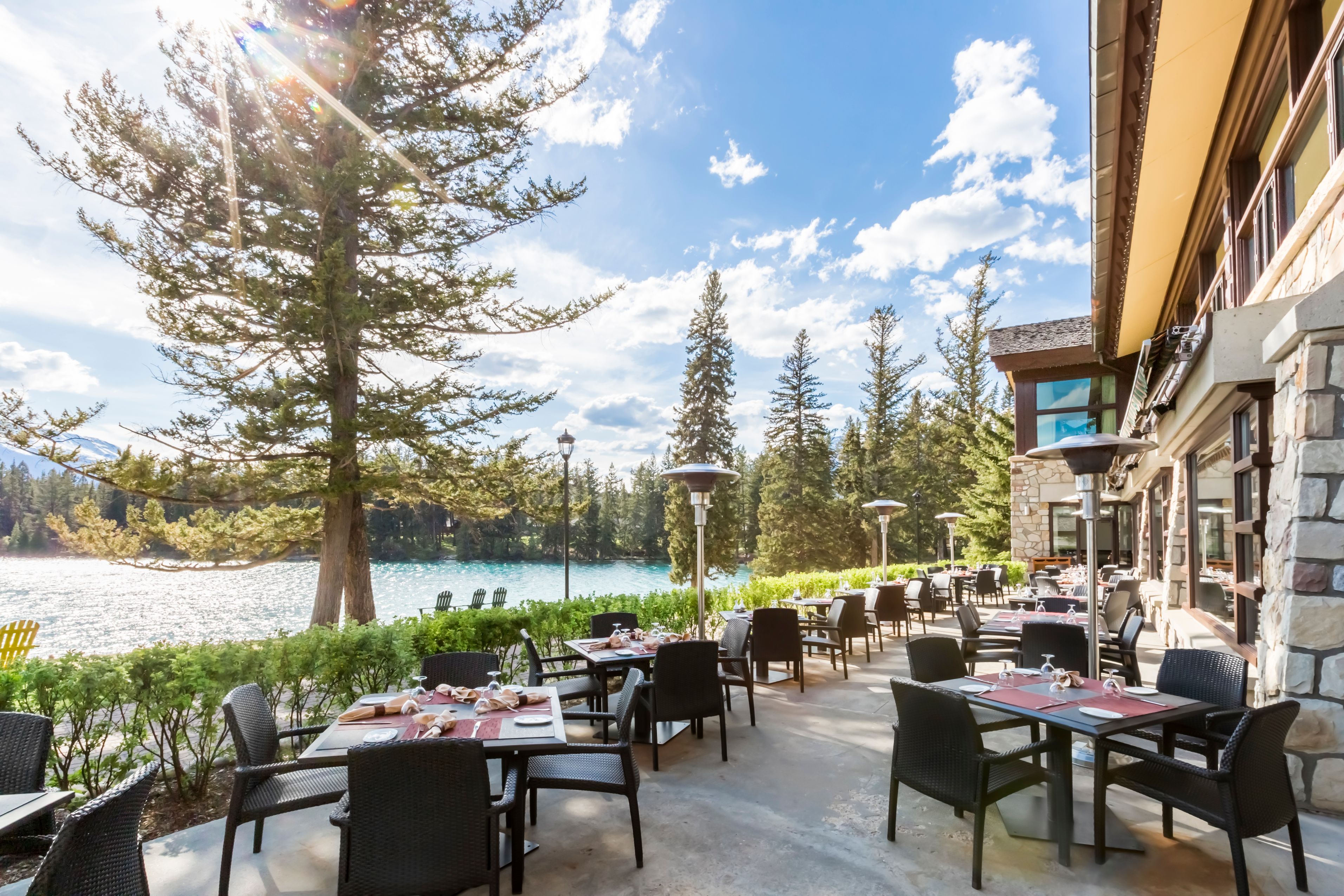 a restaurant with tables and chairs by a lake