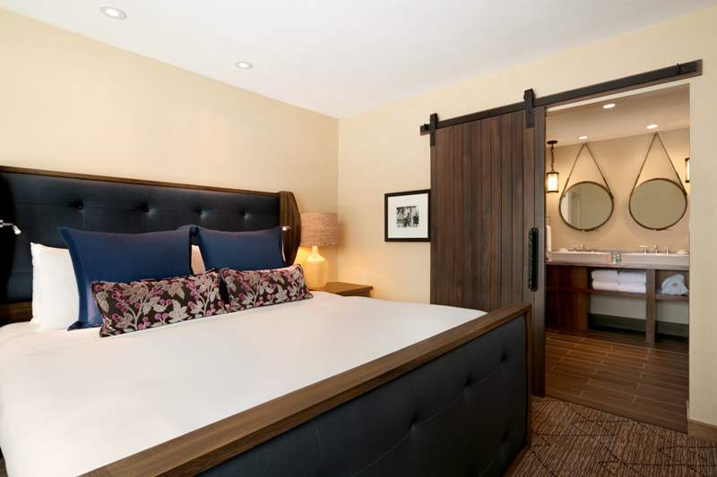 a bed with a blue headboard and a wood door