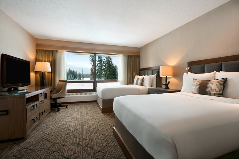 a room with two beds and a desk
