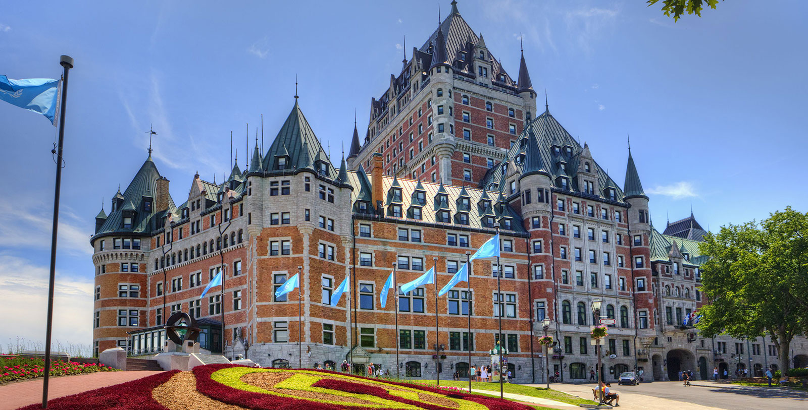 a large building with flags on the side with Château Frontenac in the background