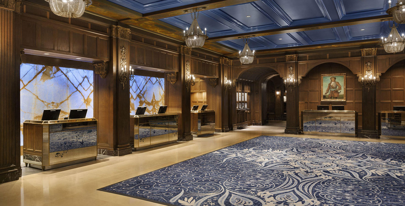 a room with a blue rug and chandeliers