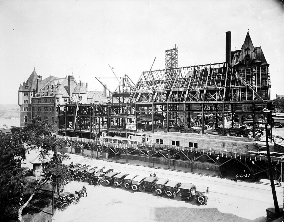 a building under construction with cars parked next to it