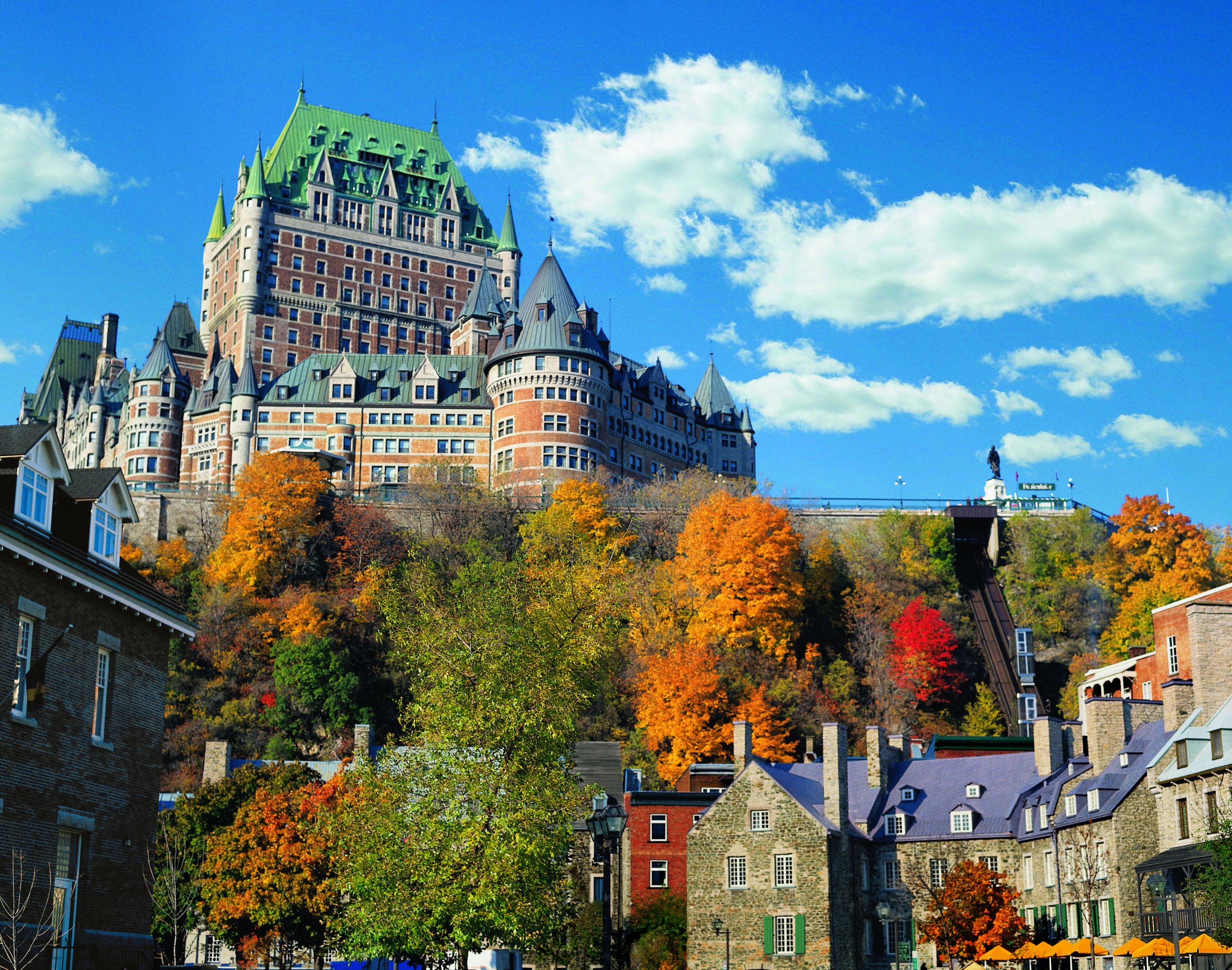 a castle on a hill with colorful trees with Château Frontenac in the background