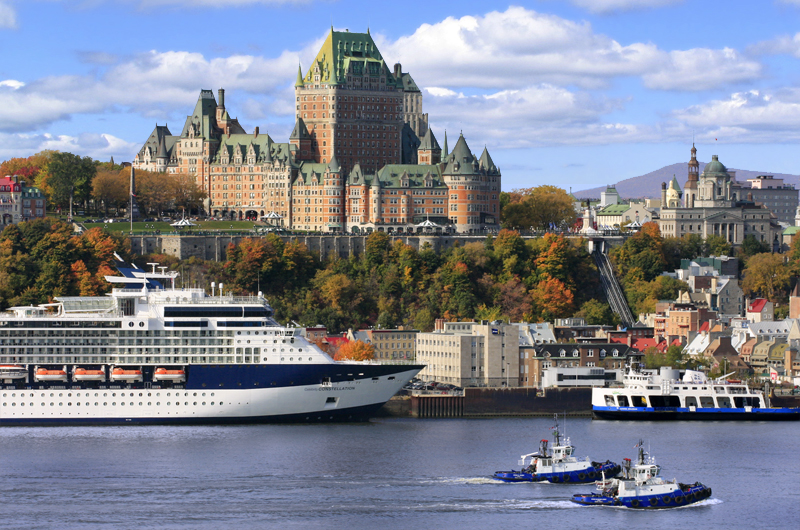 boats in a harbor with boats and a large building in the background