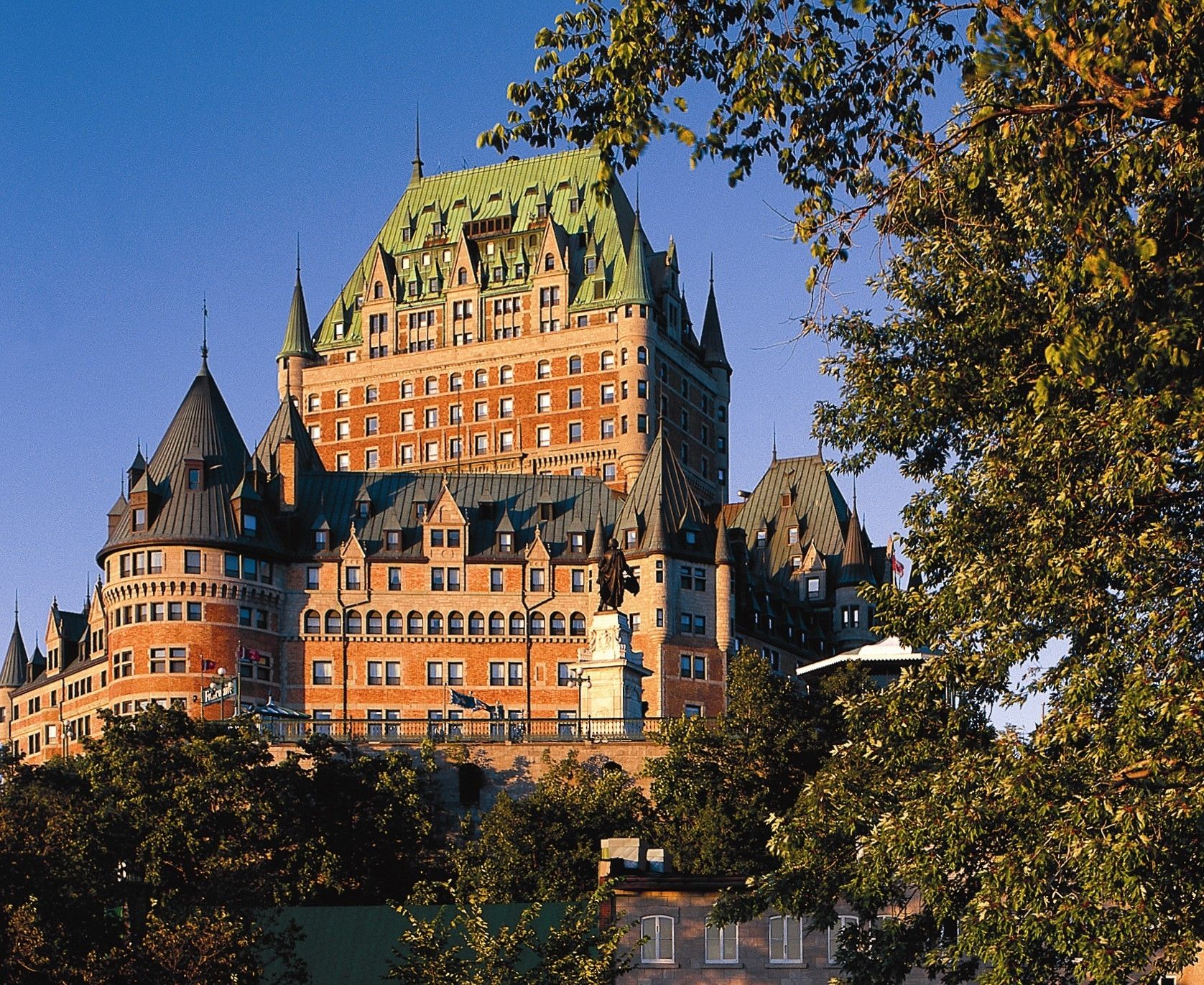 a large building with many windows with Château Frontenac in the background
