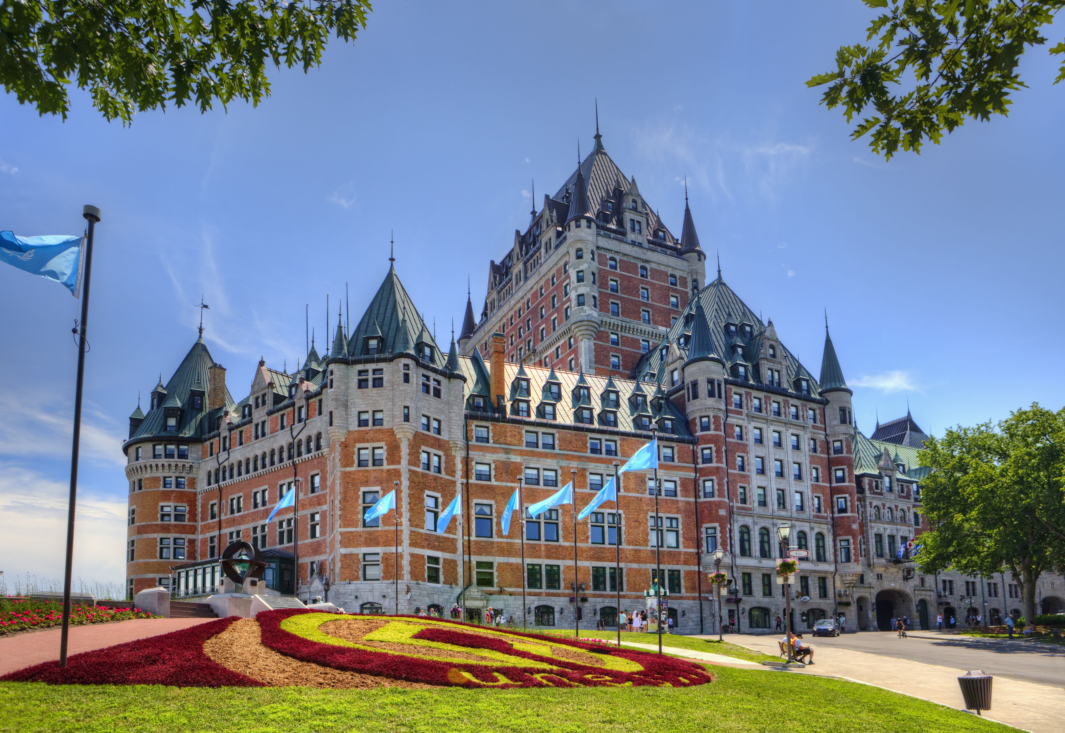 a large building with flags on it with Château Frontenac in the background