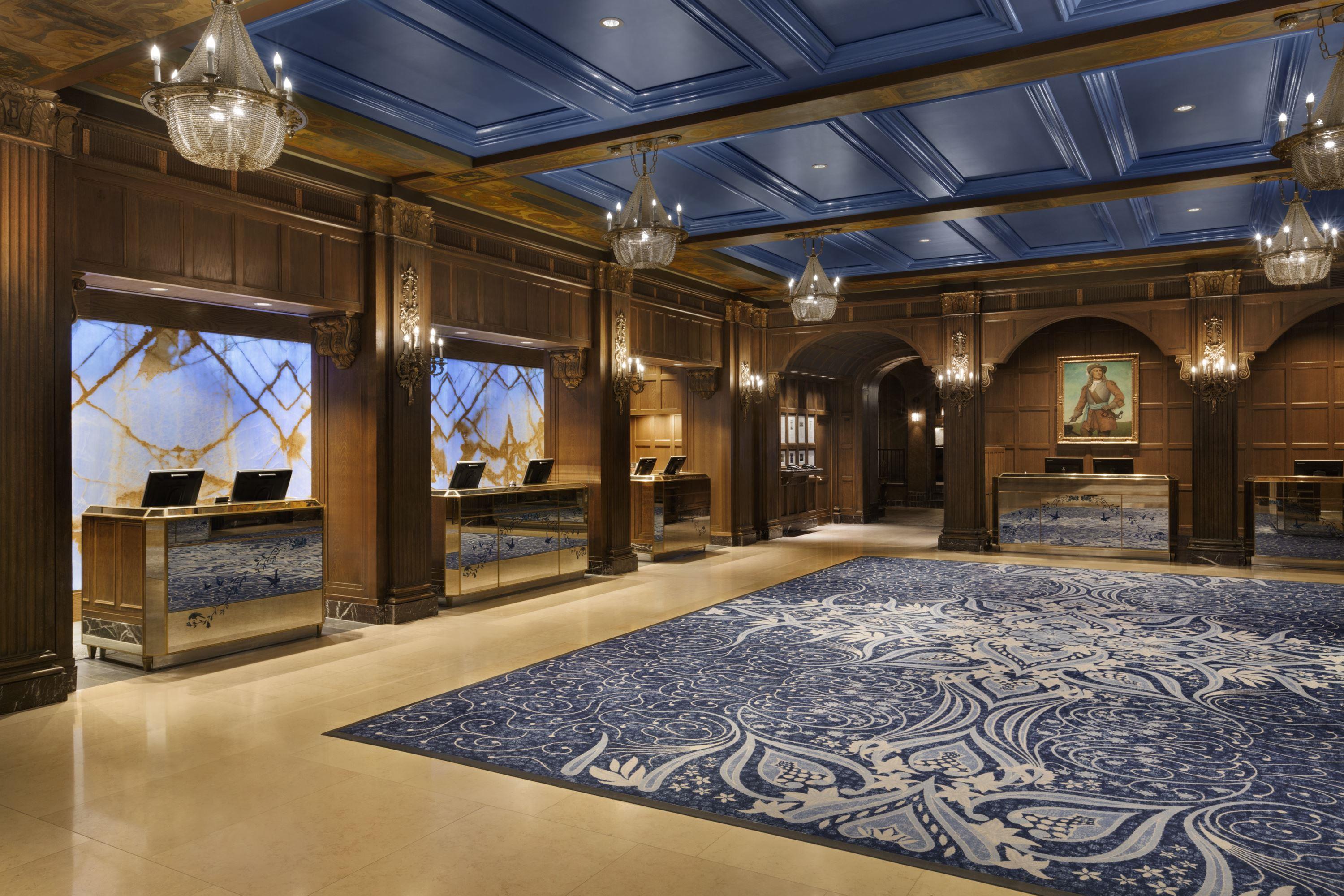 a large room with a blue rug and chandeliers