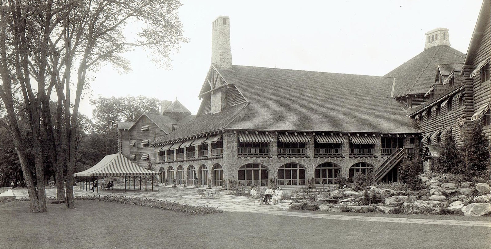 a large building with a lawn and trees