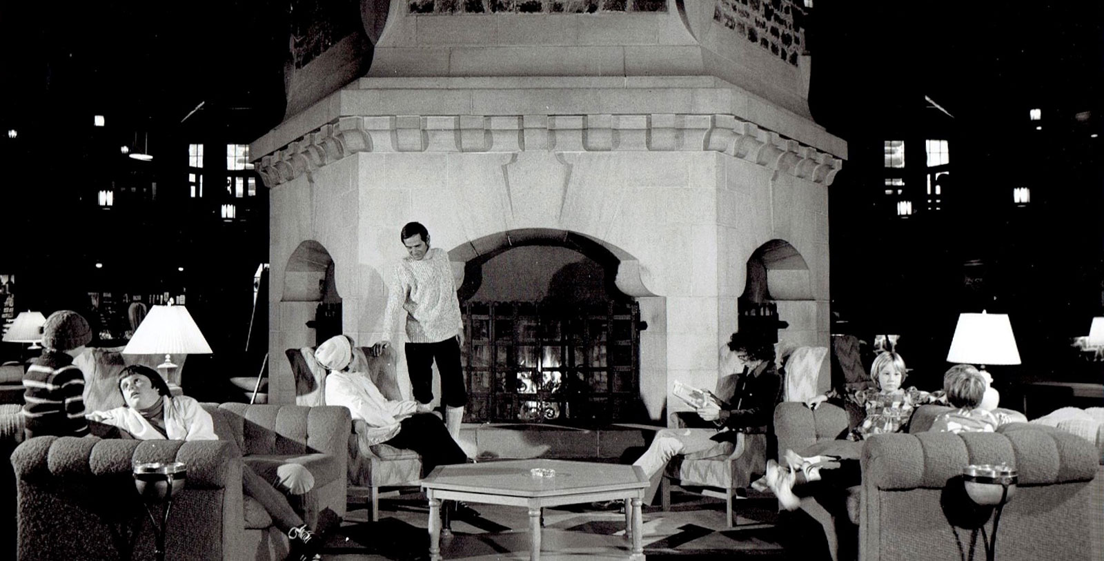 a man standing on a chair in a room with a fireplace