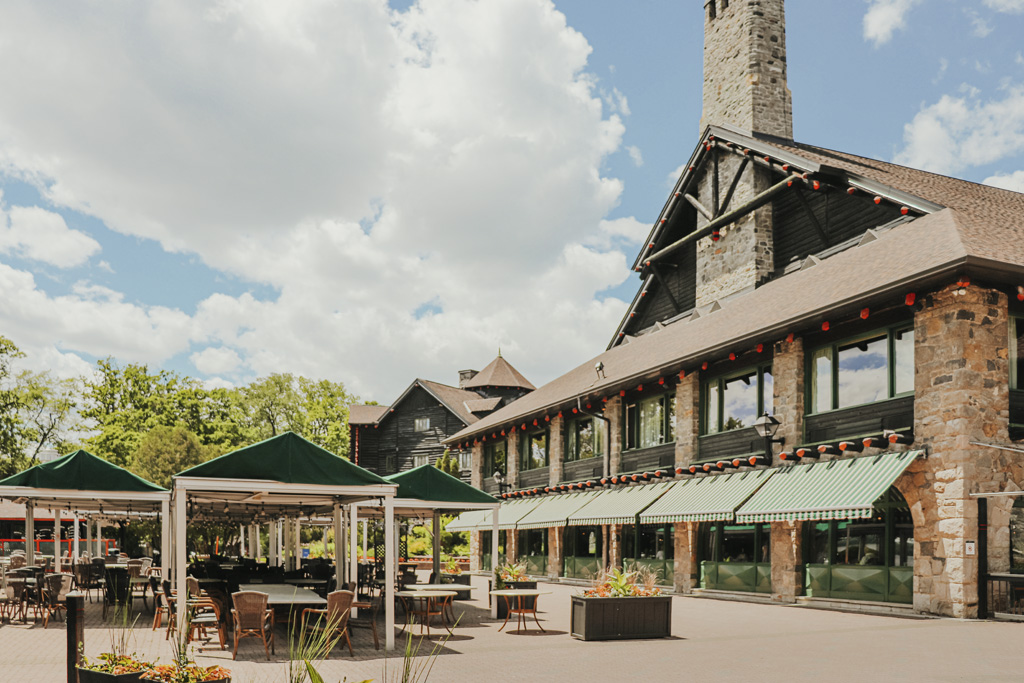 a building with a large stone chimney and tables and chairs