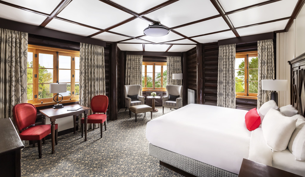 a room with a bed and chairs
