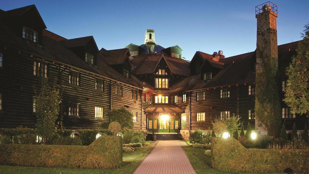 a large log cabin with a walkway
