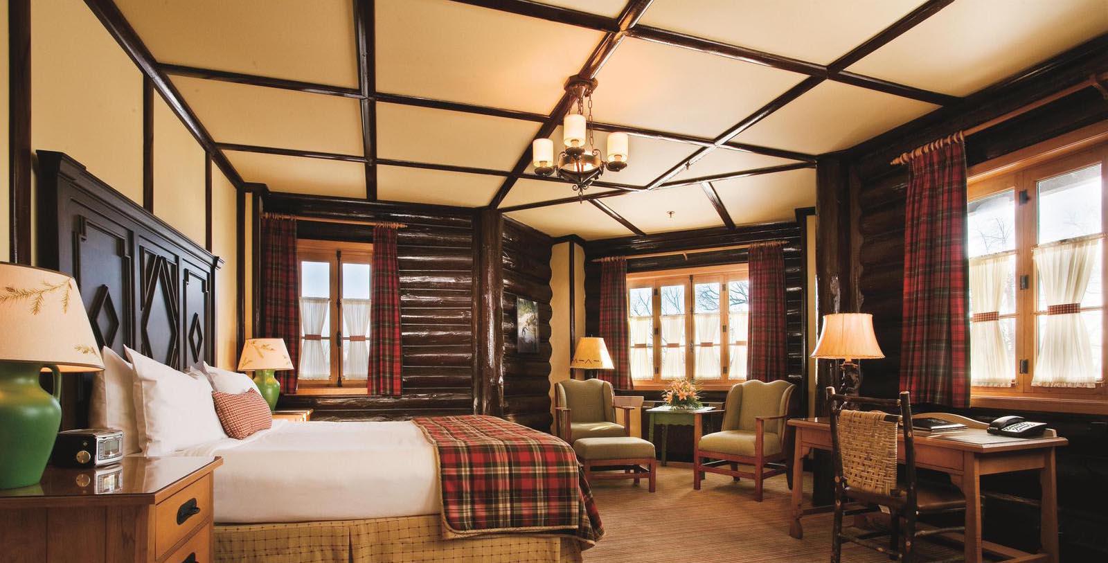 a room with a bed and chairs