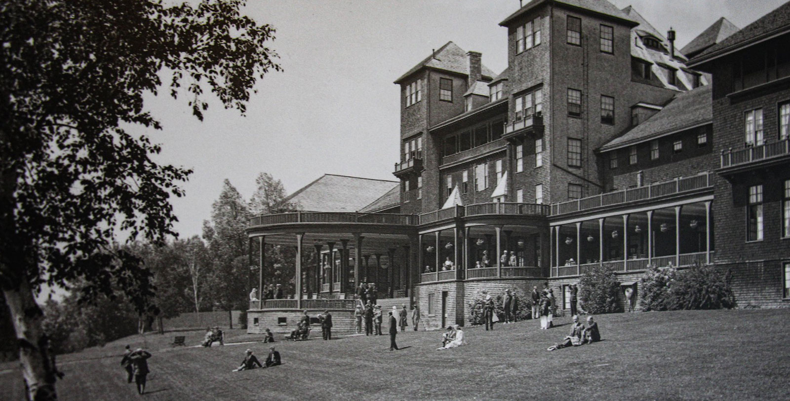 a large brick building with people sitting on grass