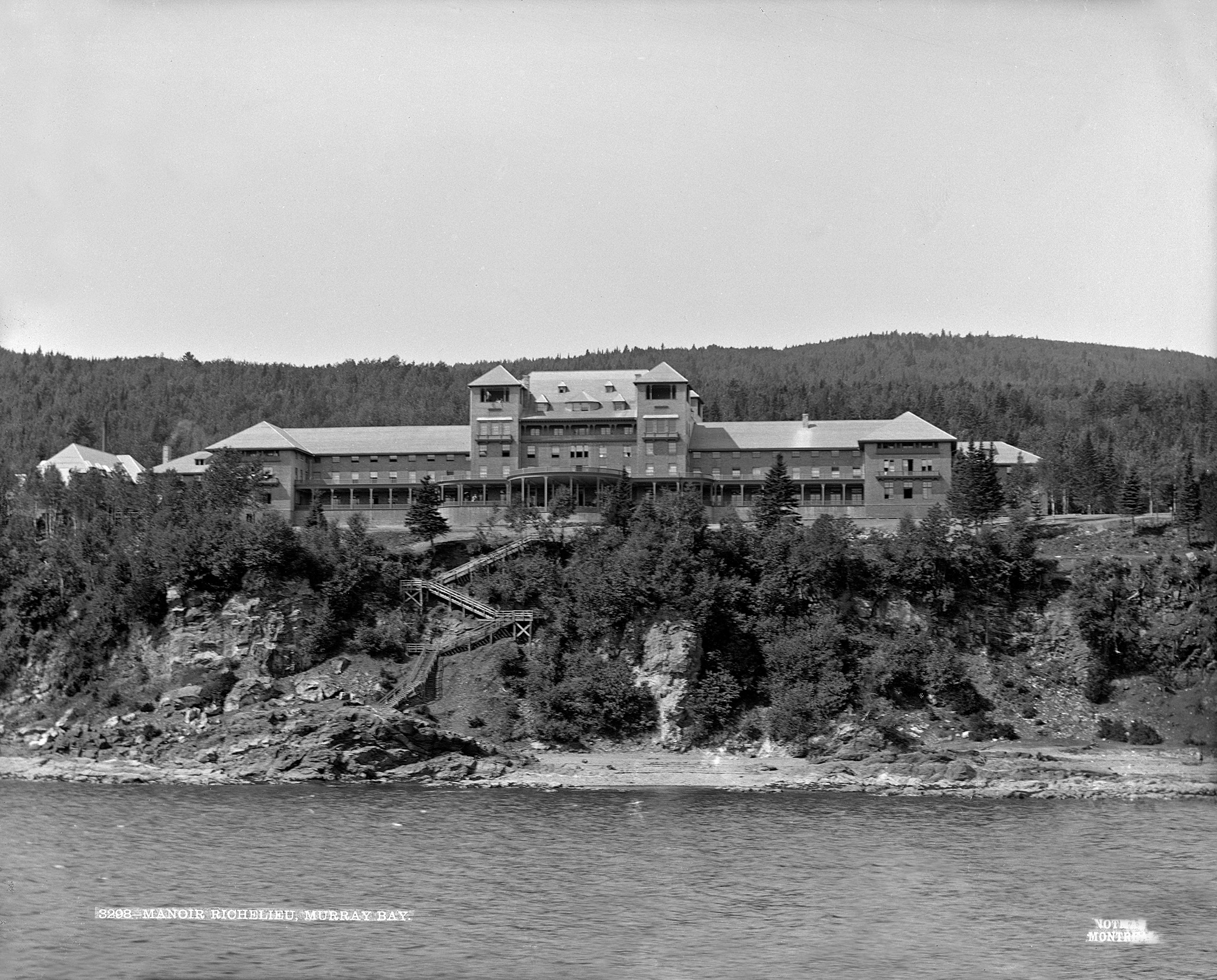 a building on a hill with trees and water