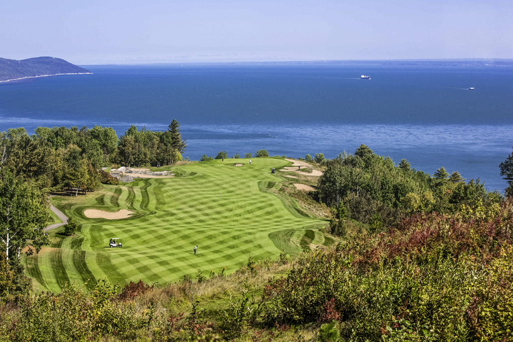 a golf course with a body of water in the background