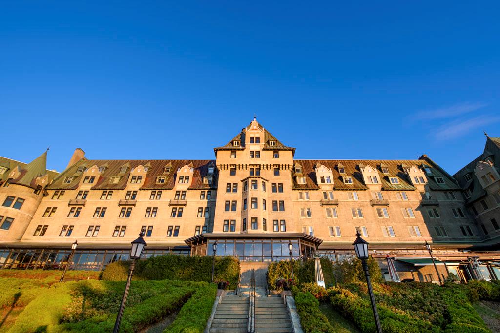 a large building with stairs and bushes
