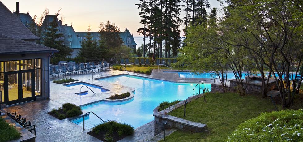 a swimming pool with a lawn and trees