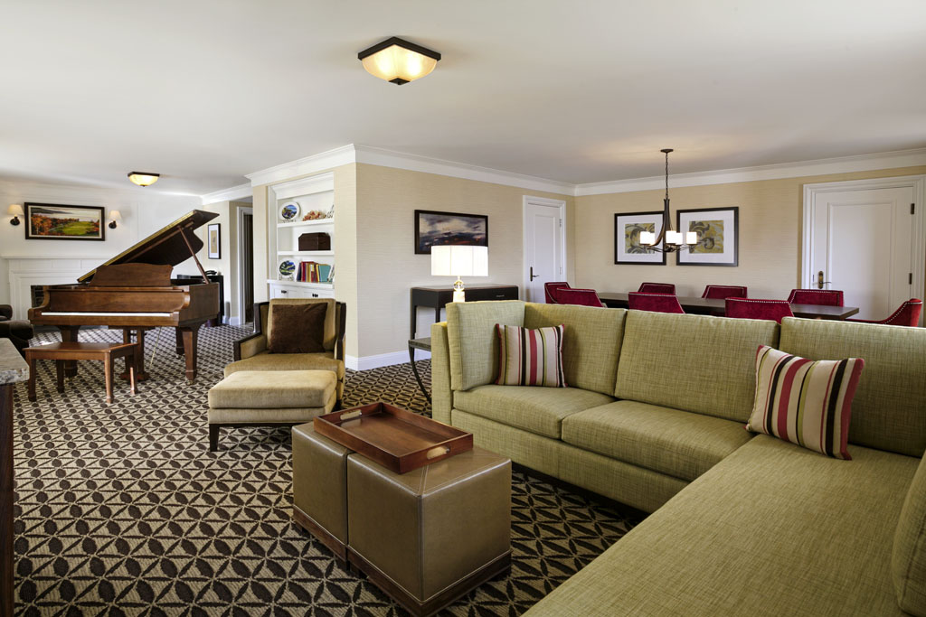 a living room with a piano and couches