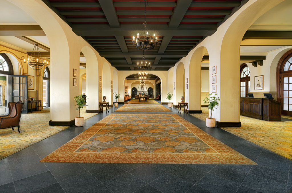 a large hall with a rug and chandelier