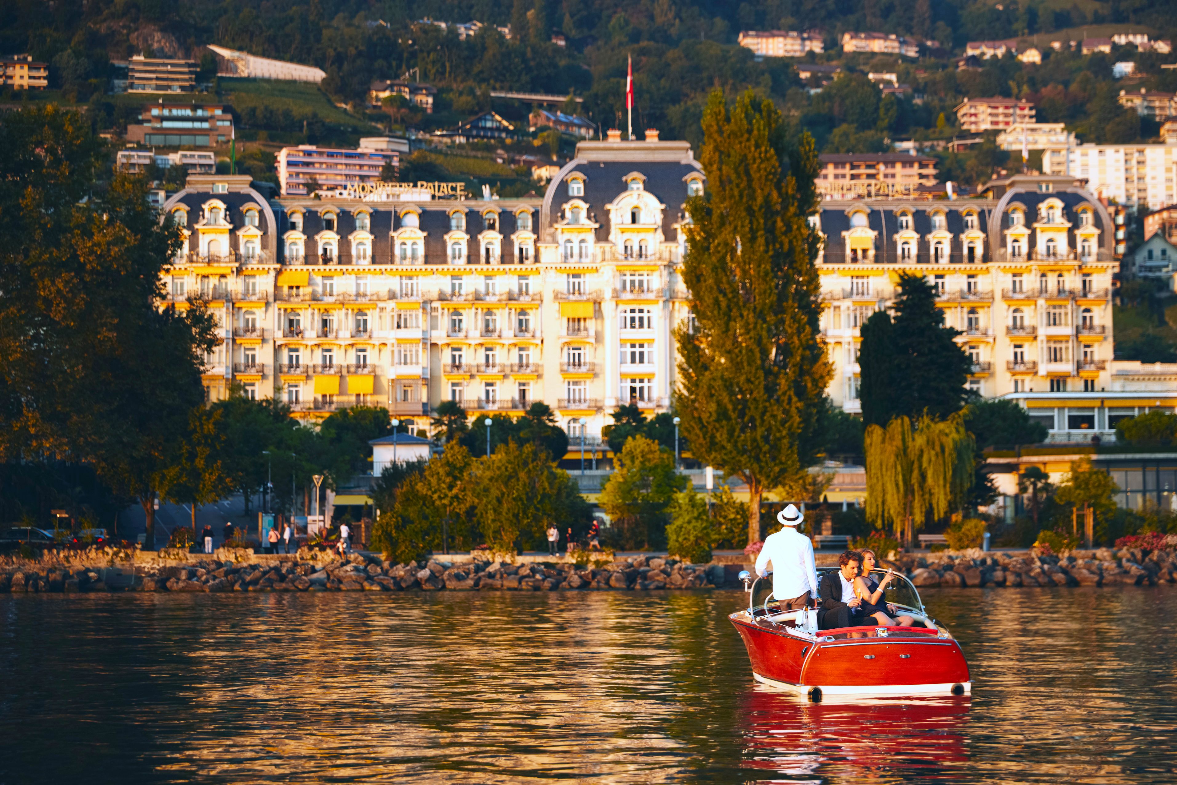 a group of people in a boat on water with a large building in the background