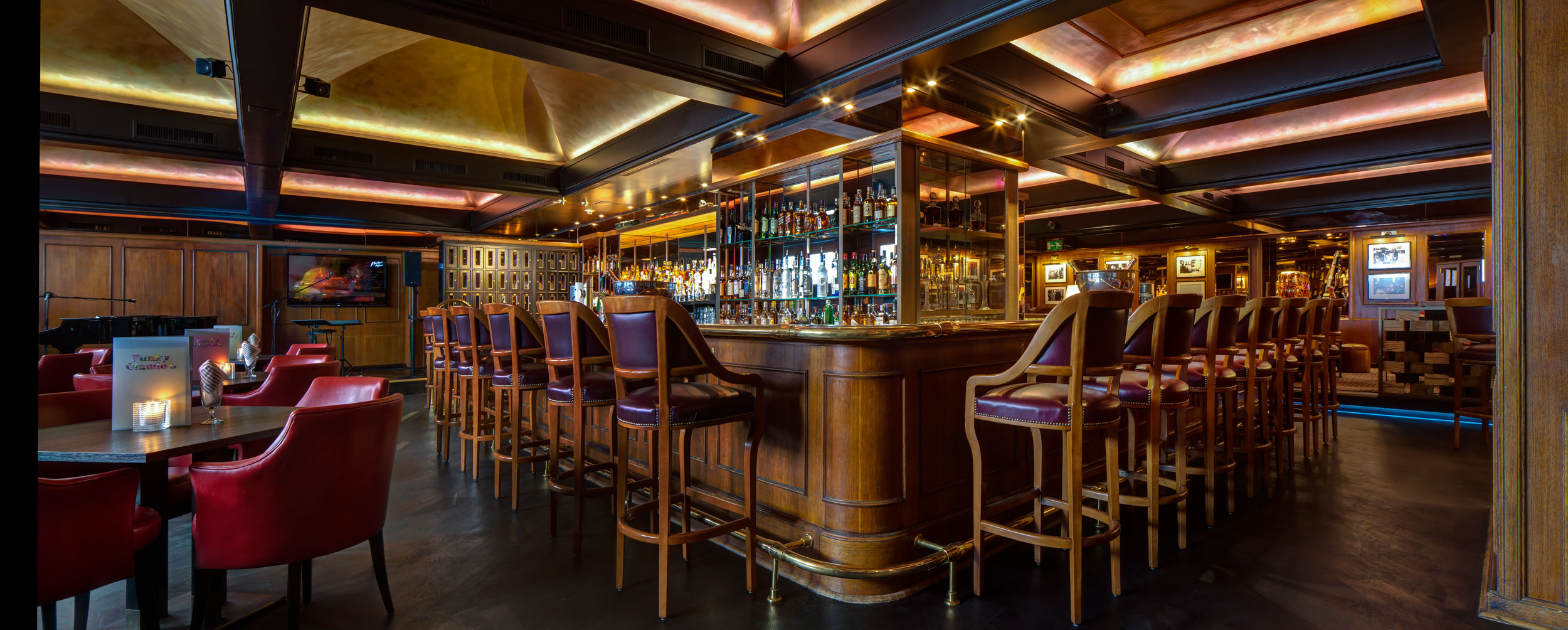 a bar with chairs and bottles