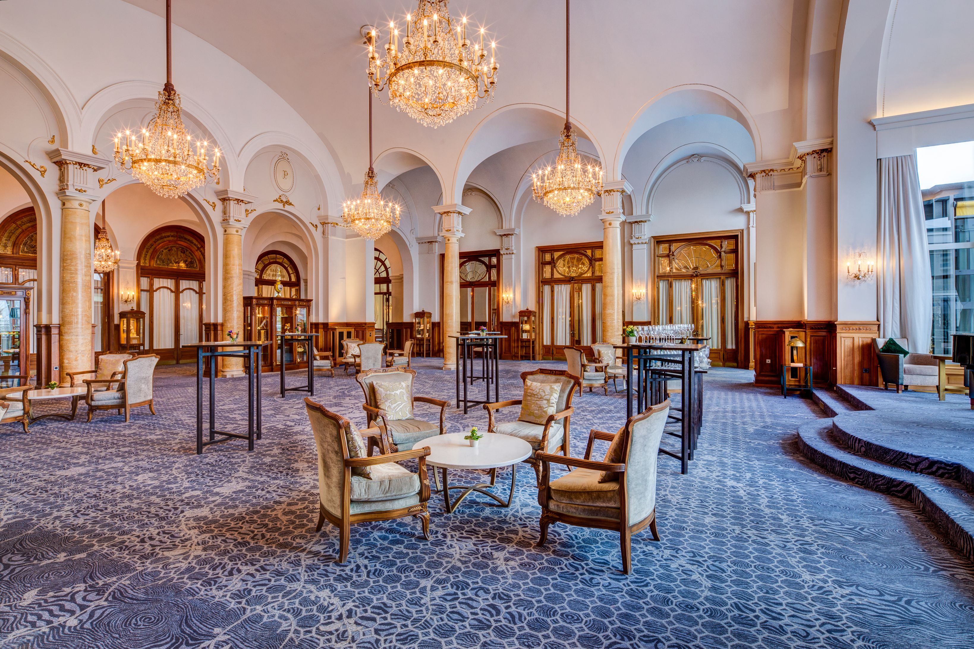 a room with chairs and tables and chandeliers