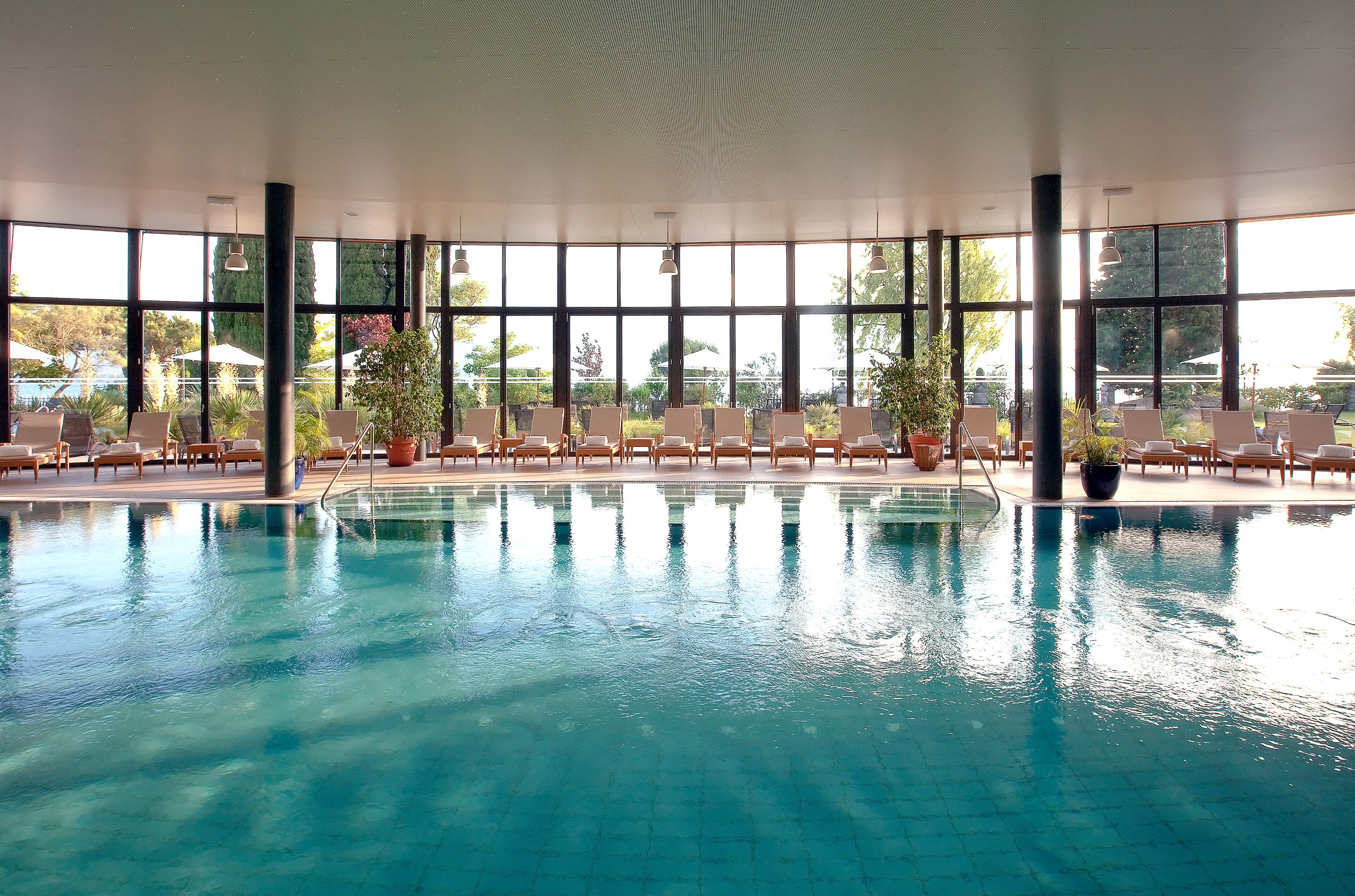a swimming pool with chairs and a large ceiling