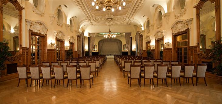 a room with chairs and chandeliers