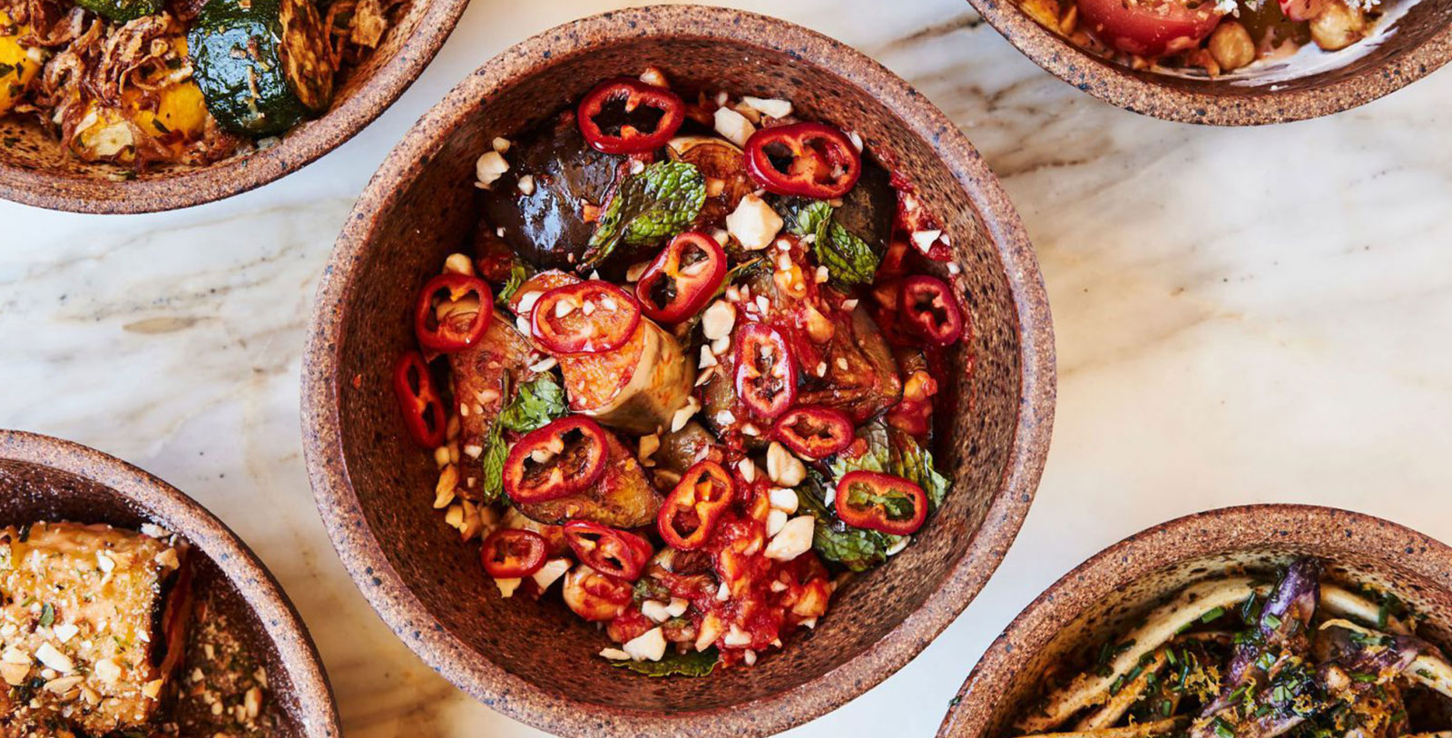 a bowl of food with red peppers and nuts