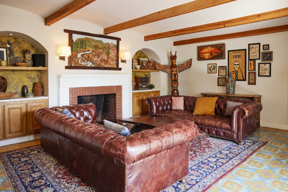a living room with a fireplace and leather couches