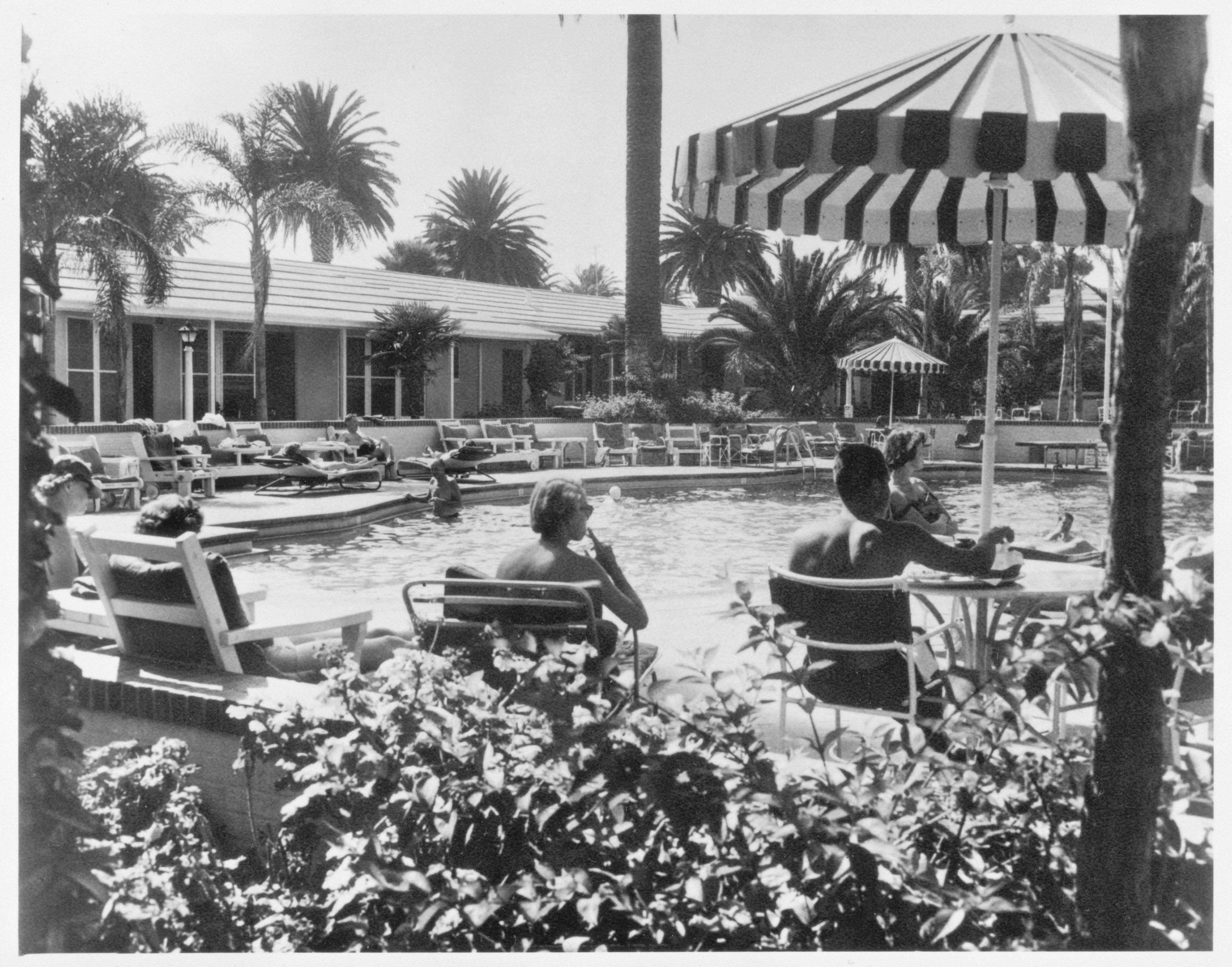 a group of people sitting at a table by a pool