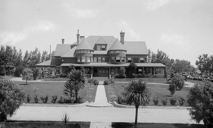 a large house with a lawn and trees