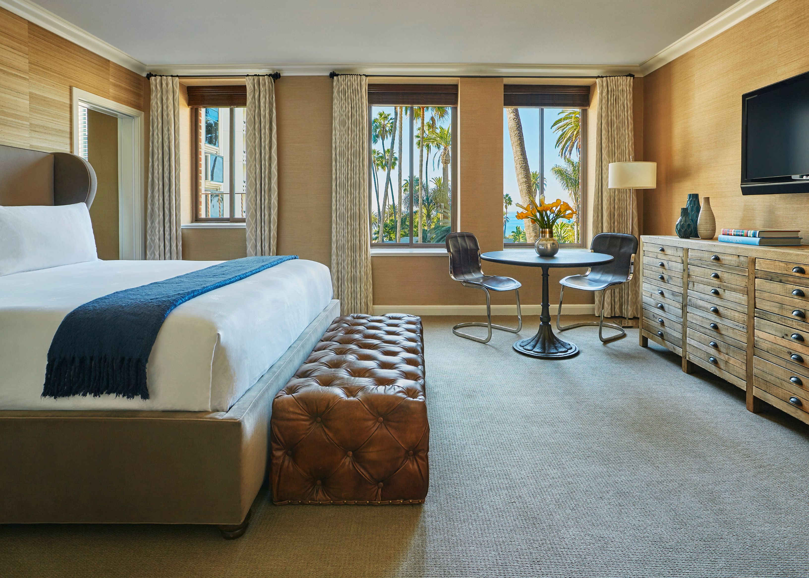 a room with a bed and chairs