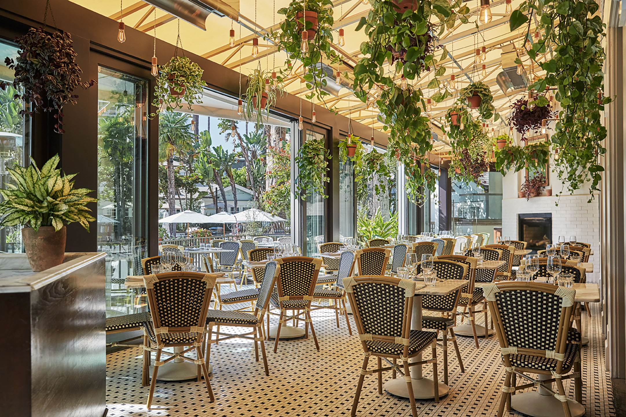 a room with tables and chairs and plants