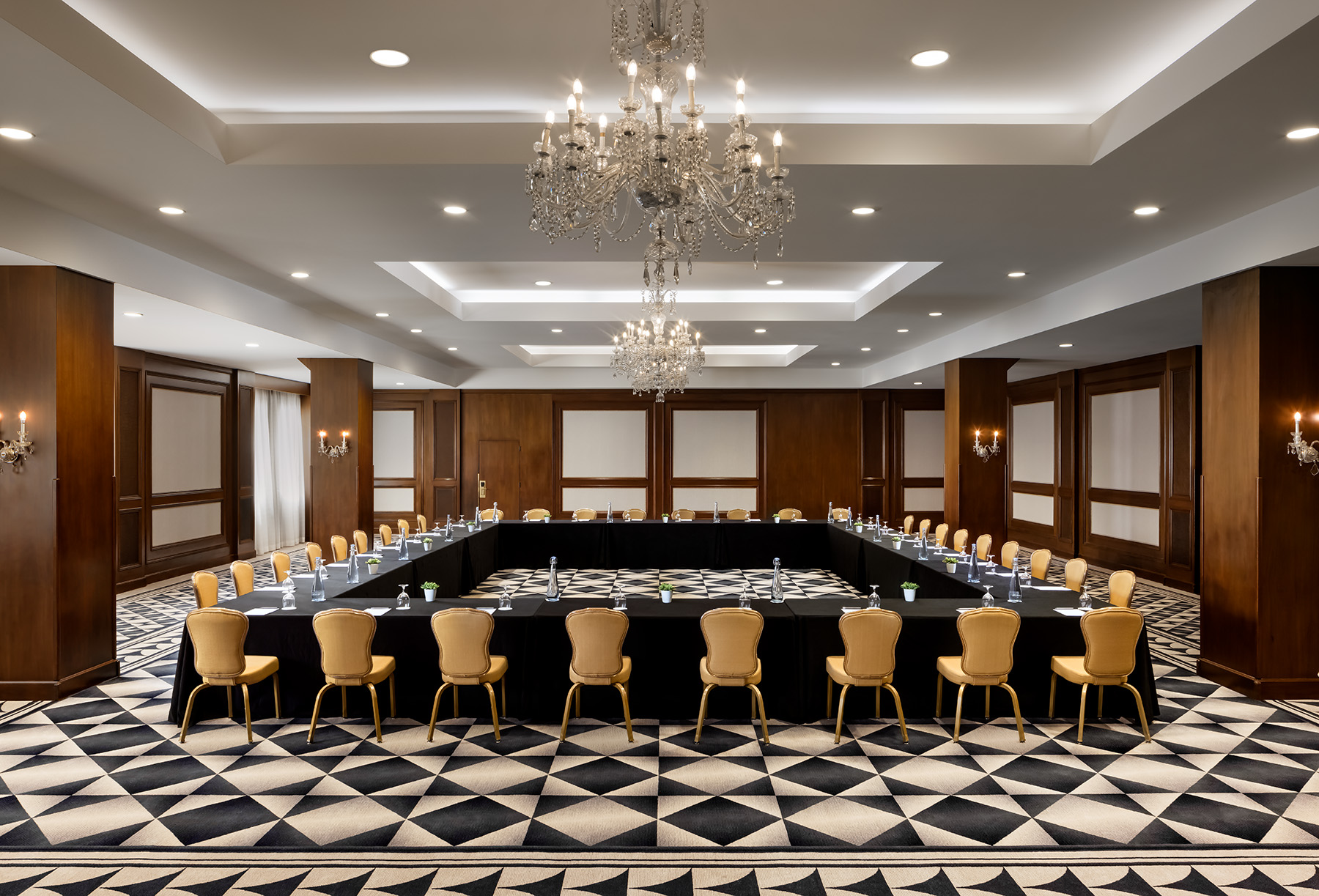 a large conference room with a large black rectangular table and chairs