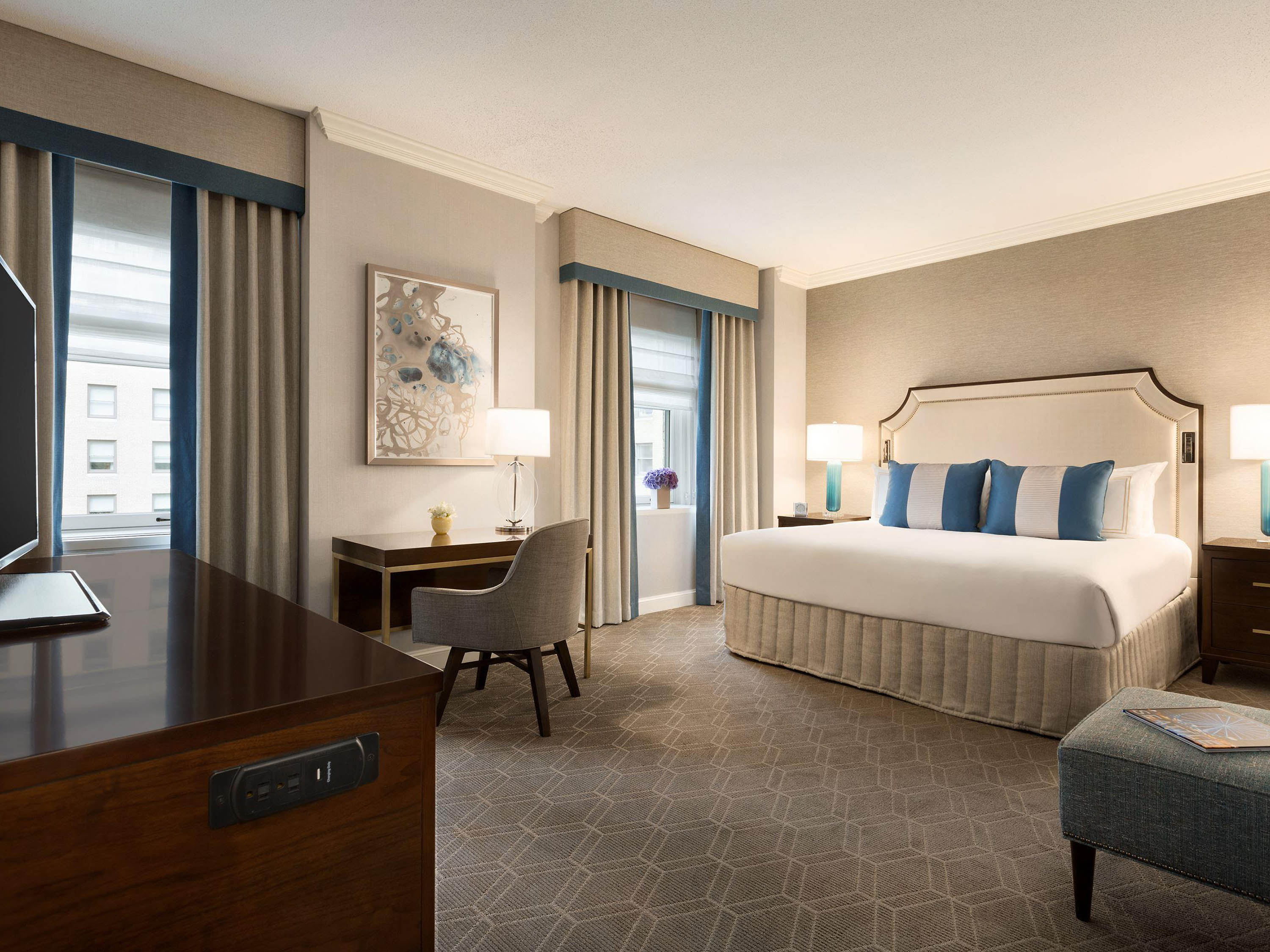 a room with a bed and chairs