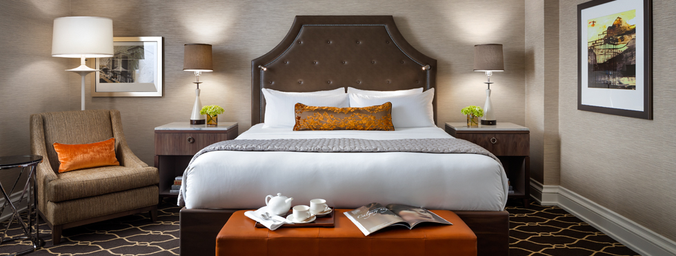 a bed with a brown headboard and a brown ottoman