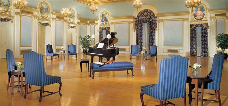 a room with a piano and chairs