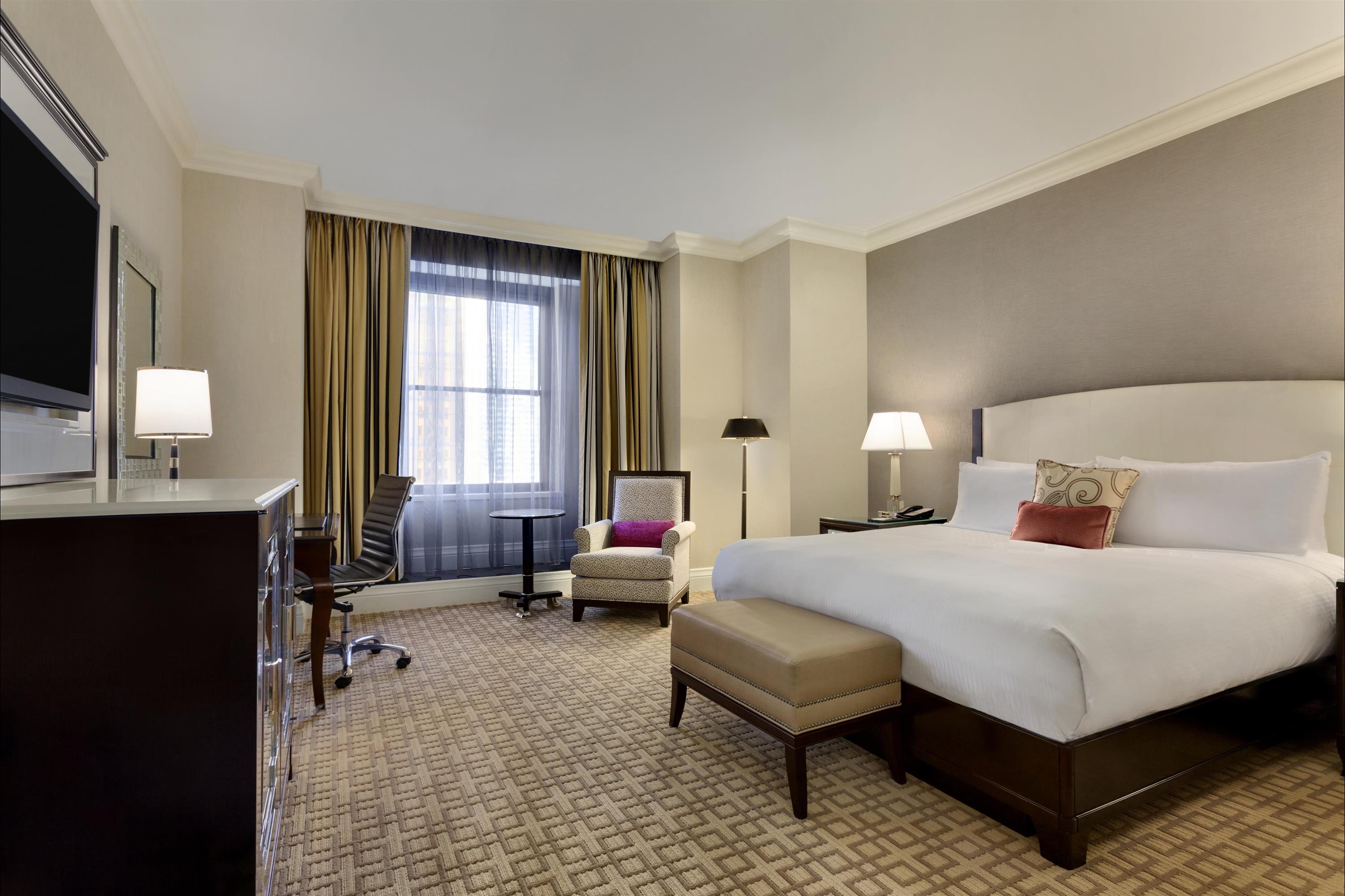 a room with a bed and chairs