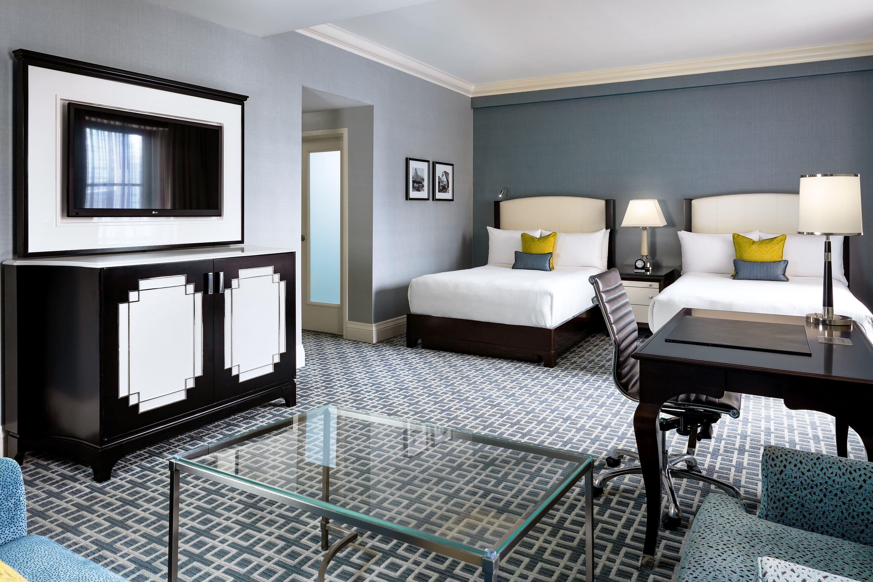 a room with two beds and a desk