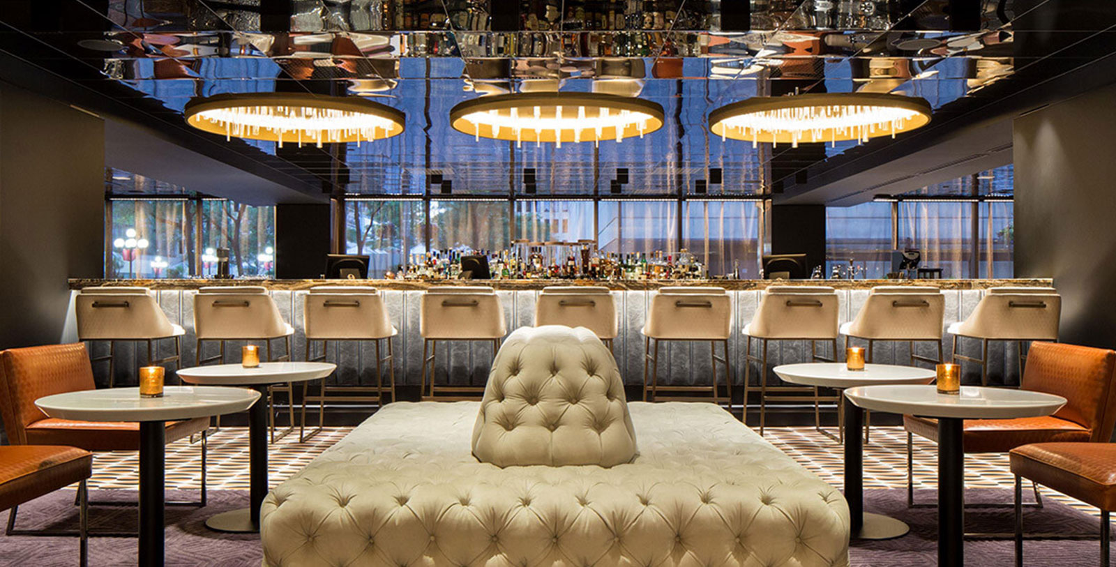 a room with a bar and a large mirror ceiling