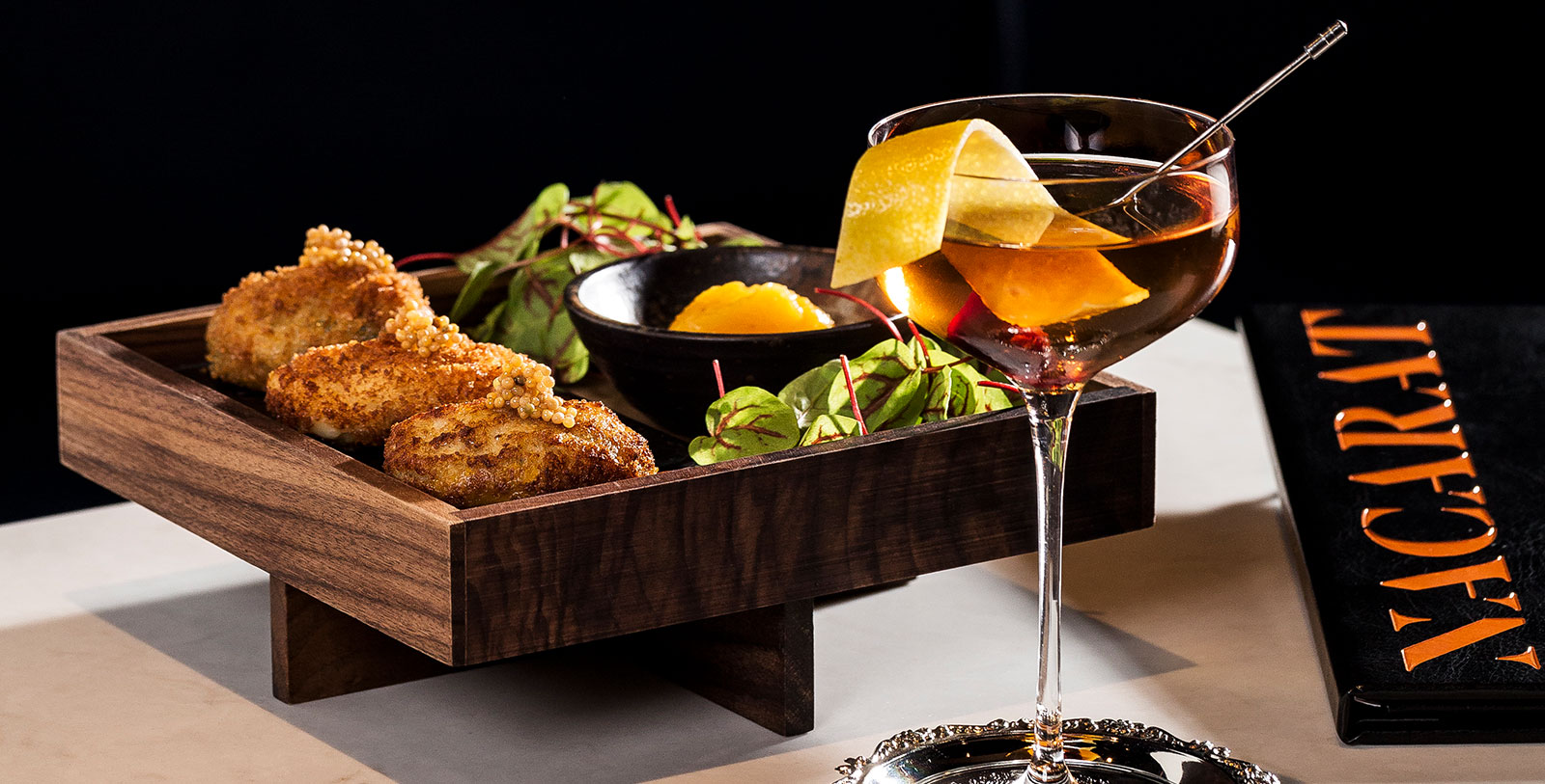a wooden tray with a drink and food on it