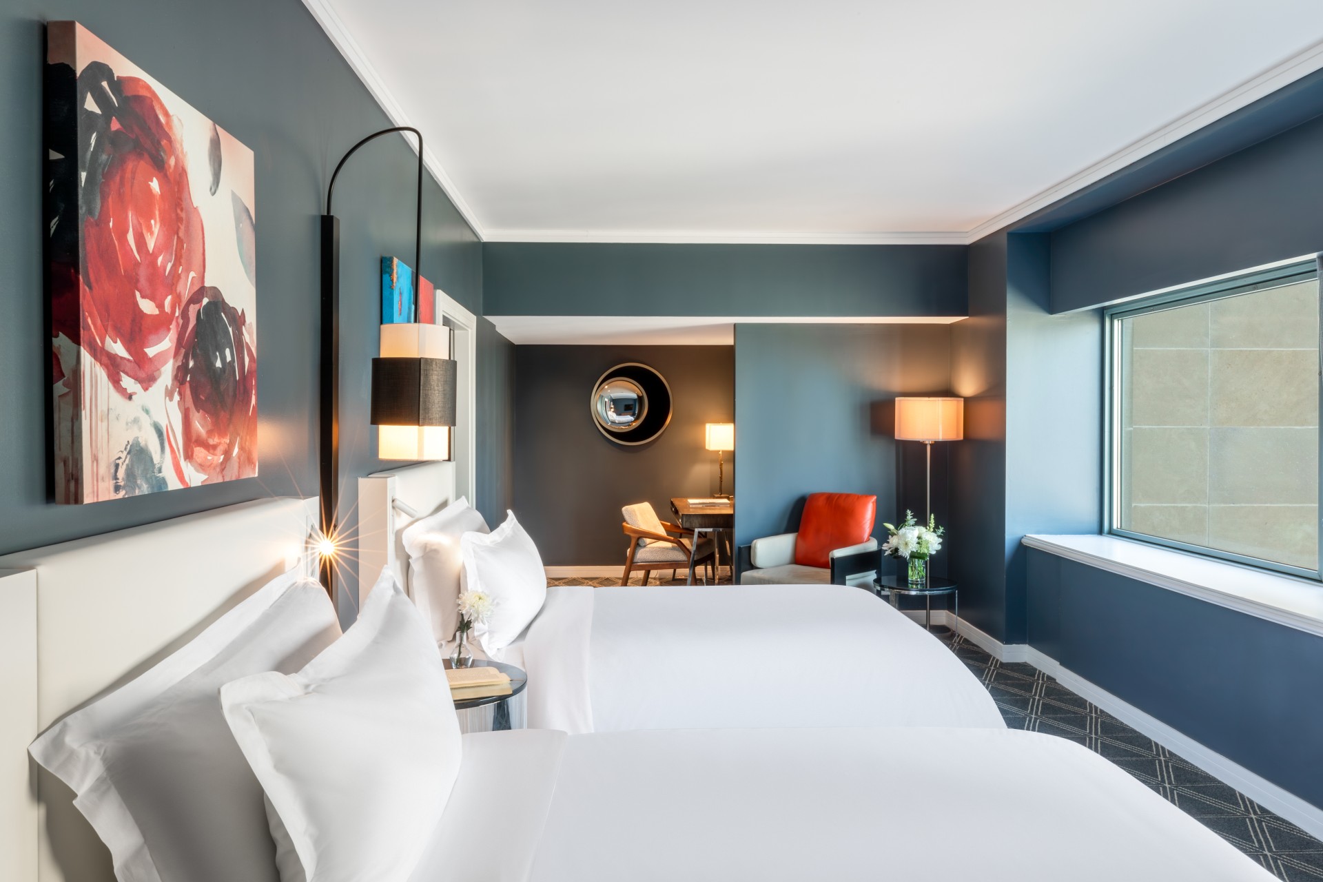 a room with two beds and a table and chairs
