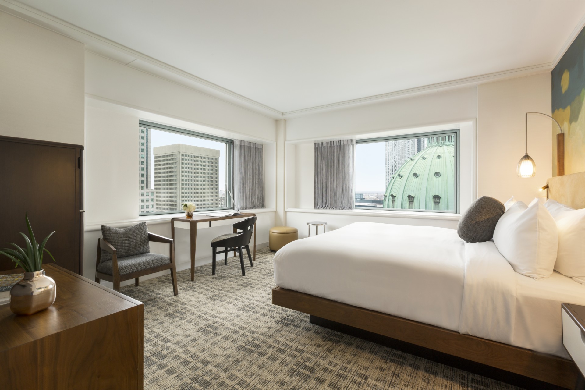 a room with a bed and a desk and chairs